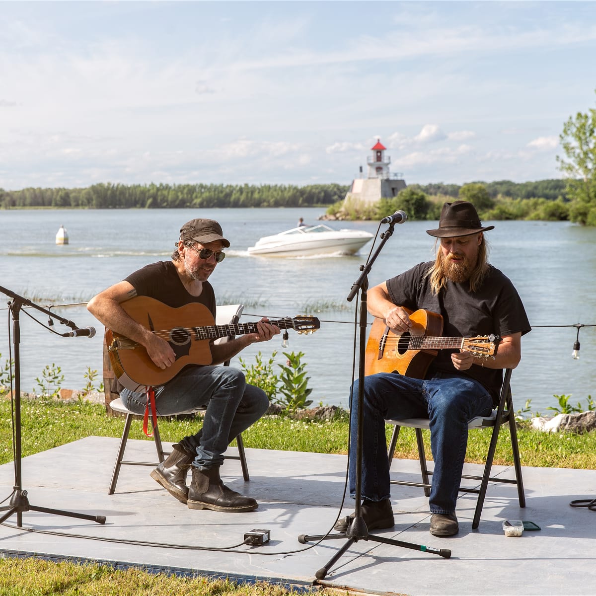 Deux guitaristes qui jouent au bord de l'eau.