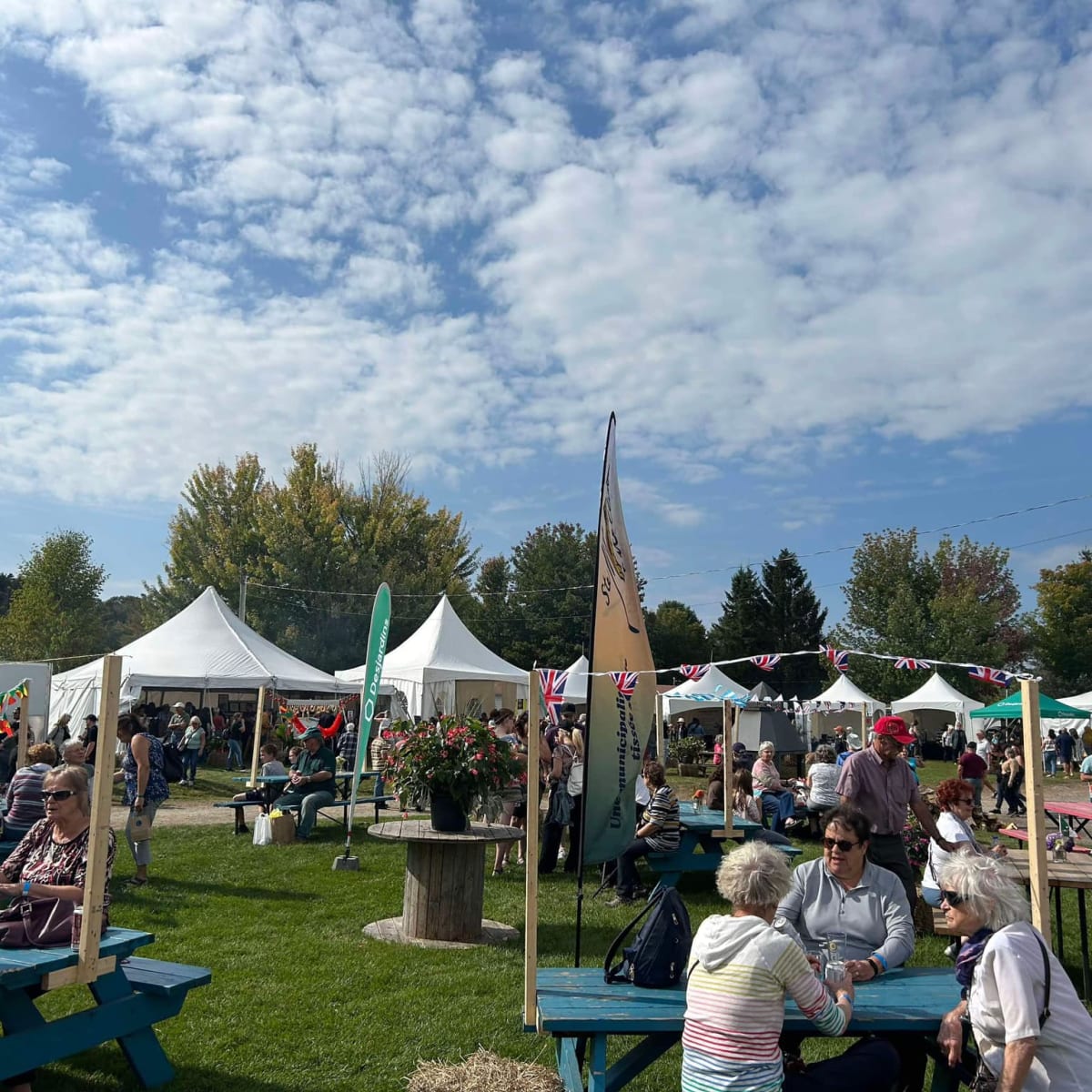 Festival des artisans de Sainte-Marcelline-de-Kildare - Un espace avec des tables de pique-nique et des chapiteaux blancs