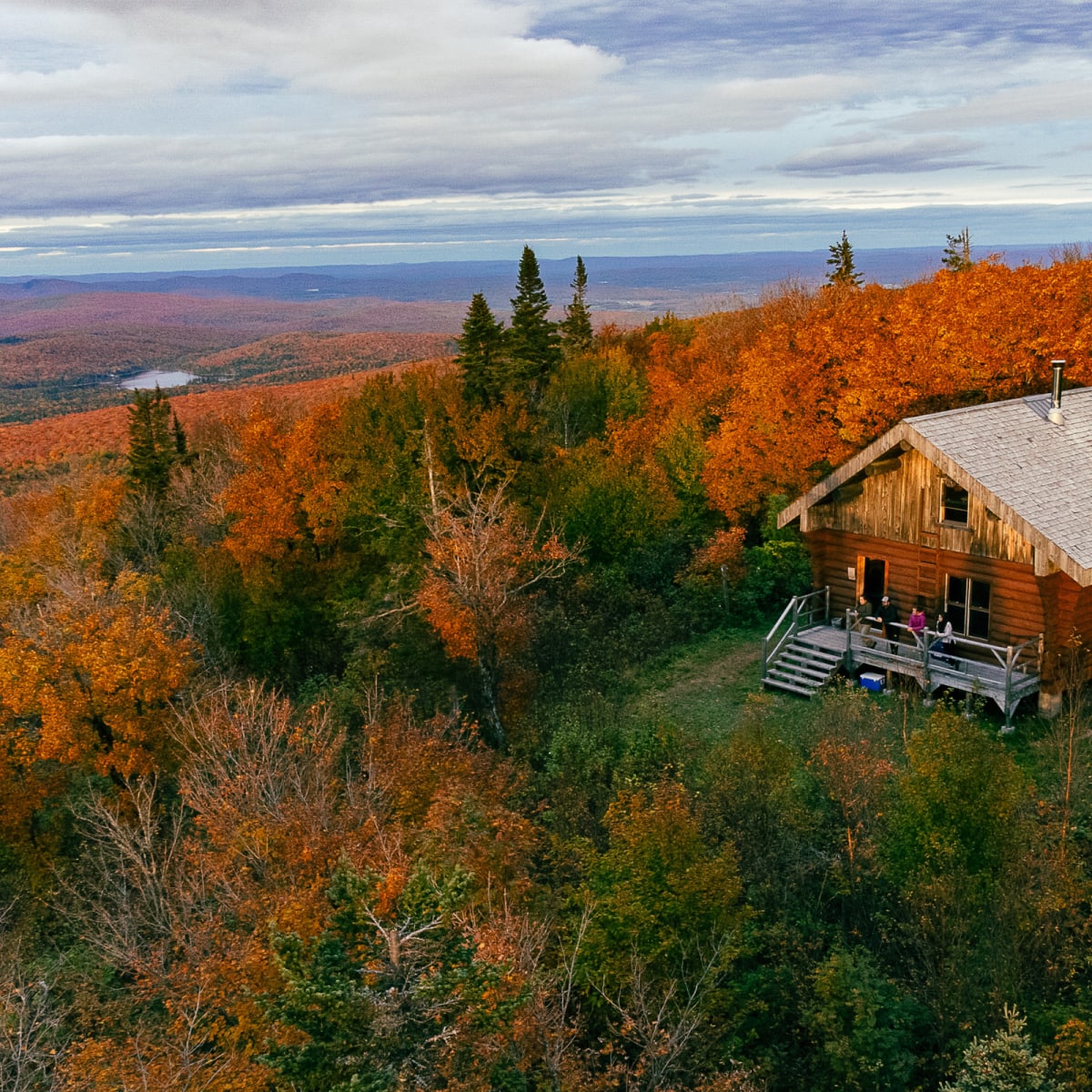 A small cabin on a mountain in Parc régional Montagne du Diable in autumn.