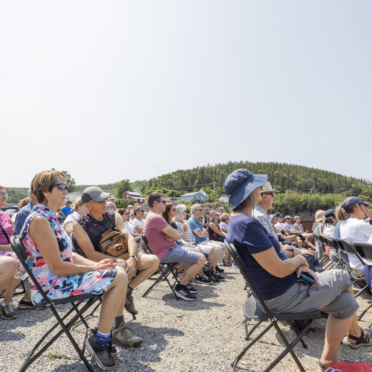 Foule assise pour un spectacle au bord de la mer au Festival en chanson de Petite-Vallée.