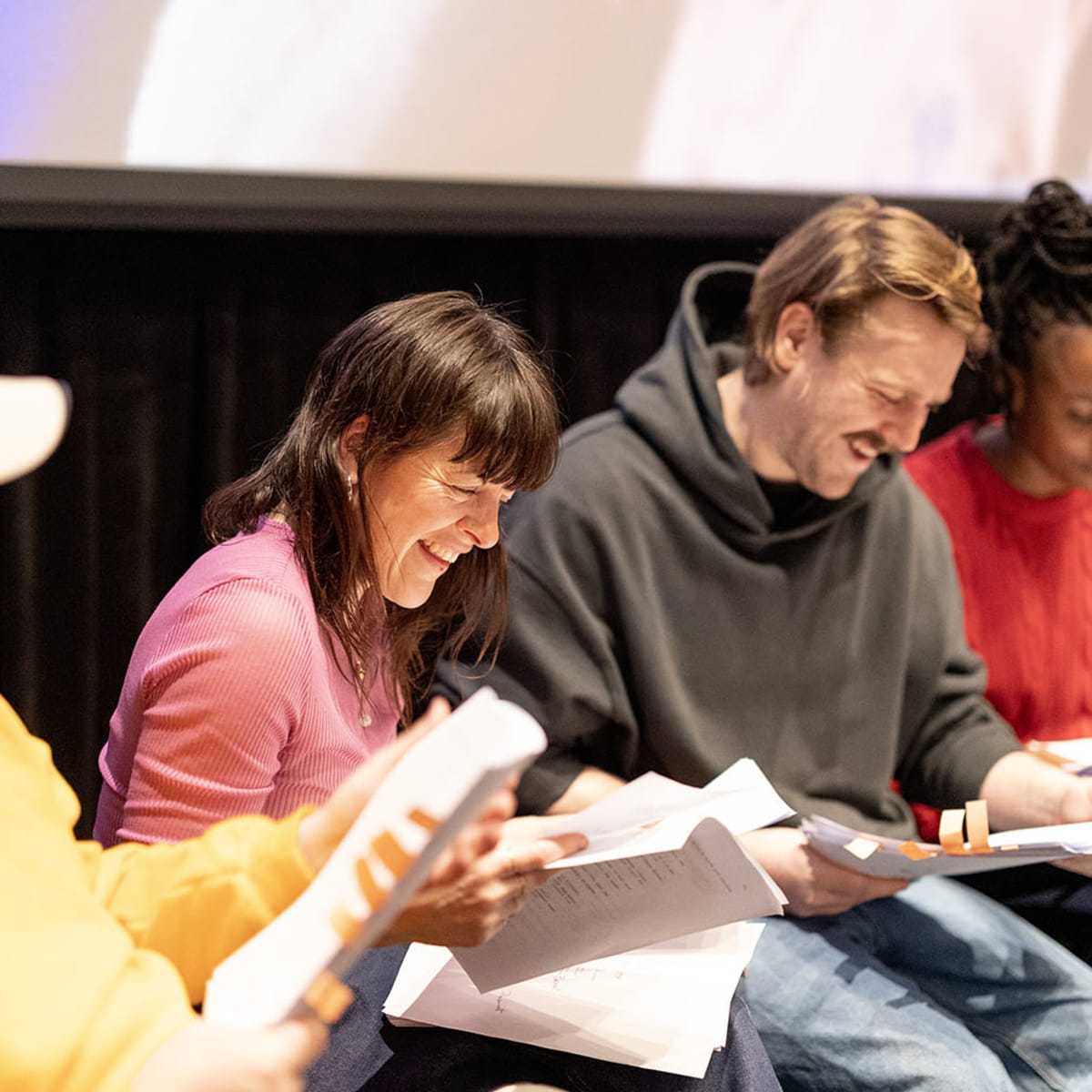 Festival Plein(s) Écran(s) - Un groupe de personnes assises côte à côte, penchées sur des scripts