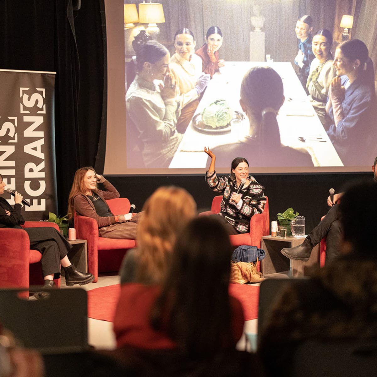 Festival Plein(s) Écran(s) - Un panel de personnes discute sur une scène, avec une projection derrière eux 