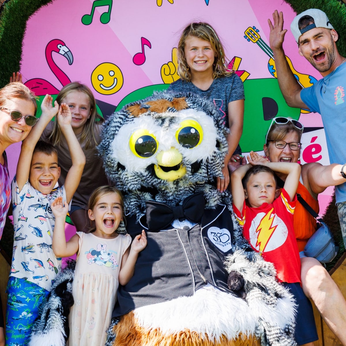 A family having fun with a mascot at the Festival POP ton été