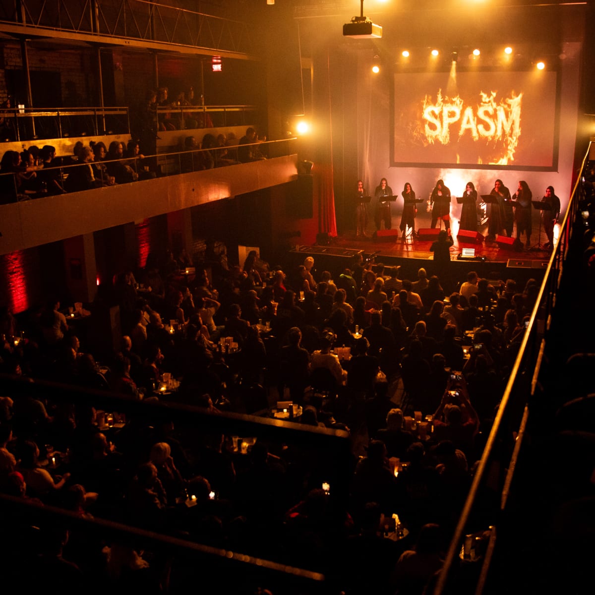Festival SPASM -  Salle de spectacle sombre et remplie de spectateurs.