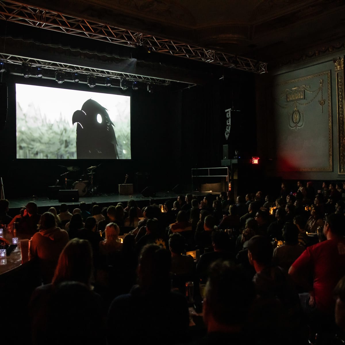 Festival SPASM - Un corbeau est projeté sur l'écran d'une scène.
