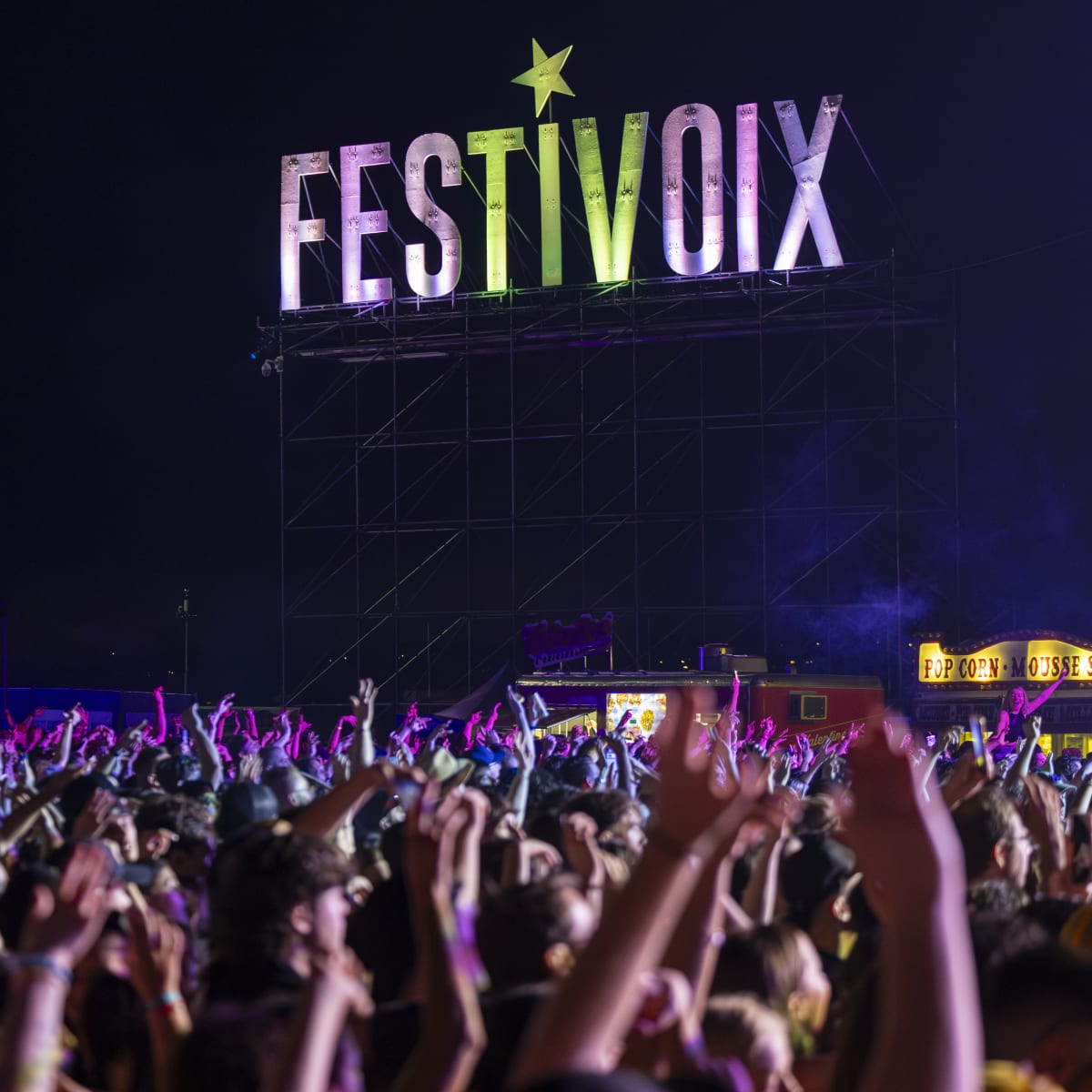 A crowd with their arms raised at the FestiVoix festival in Trois-Rivières.