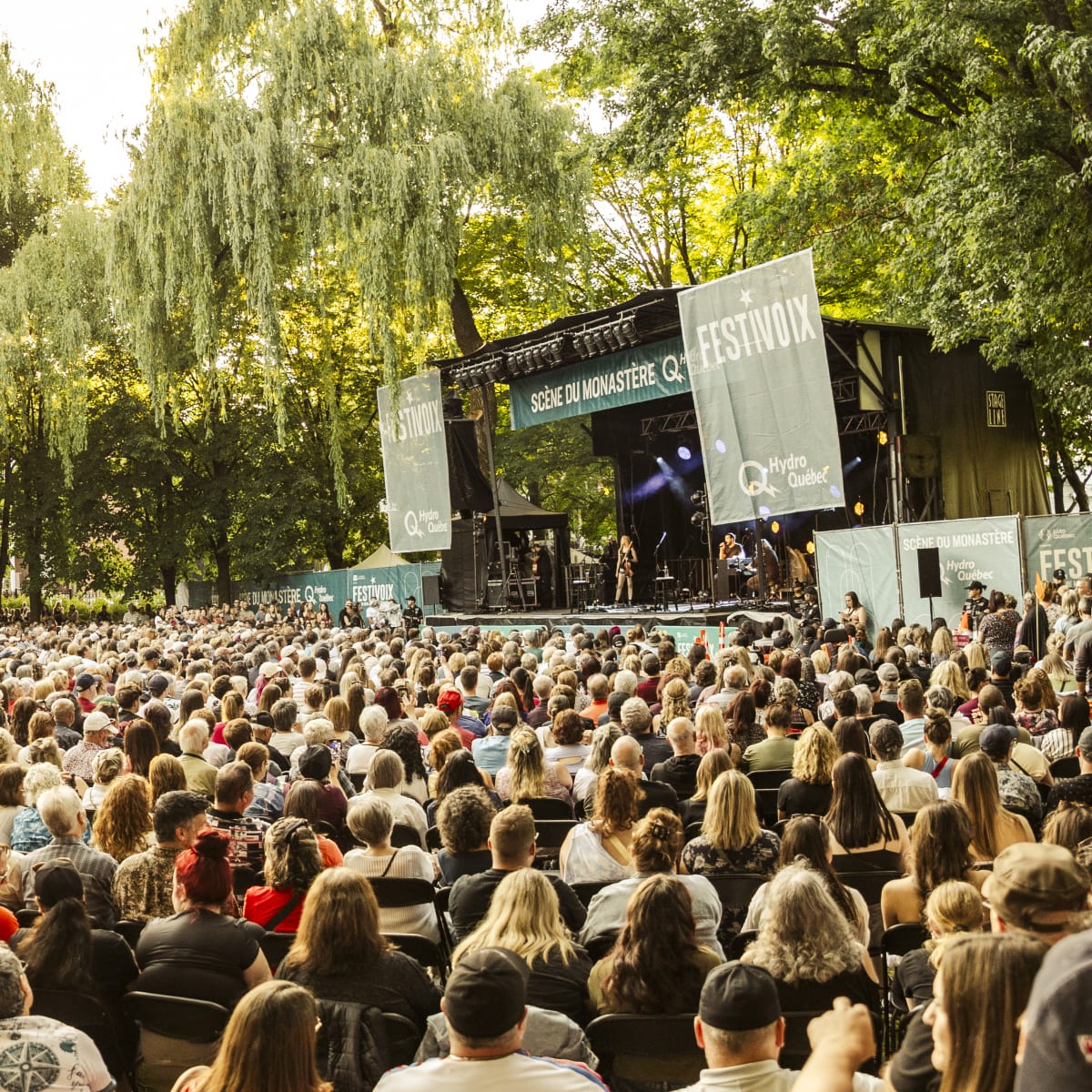 A crowd seated in front of an outdoor stage at the FestiVoix festival in Trois-Rivières.