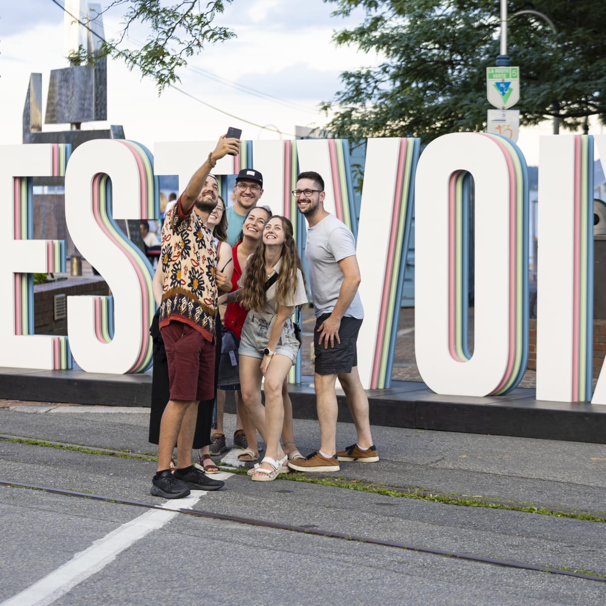 Friends taking a selfie in front of FestiVoix de Trois-Rivières.