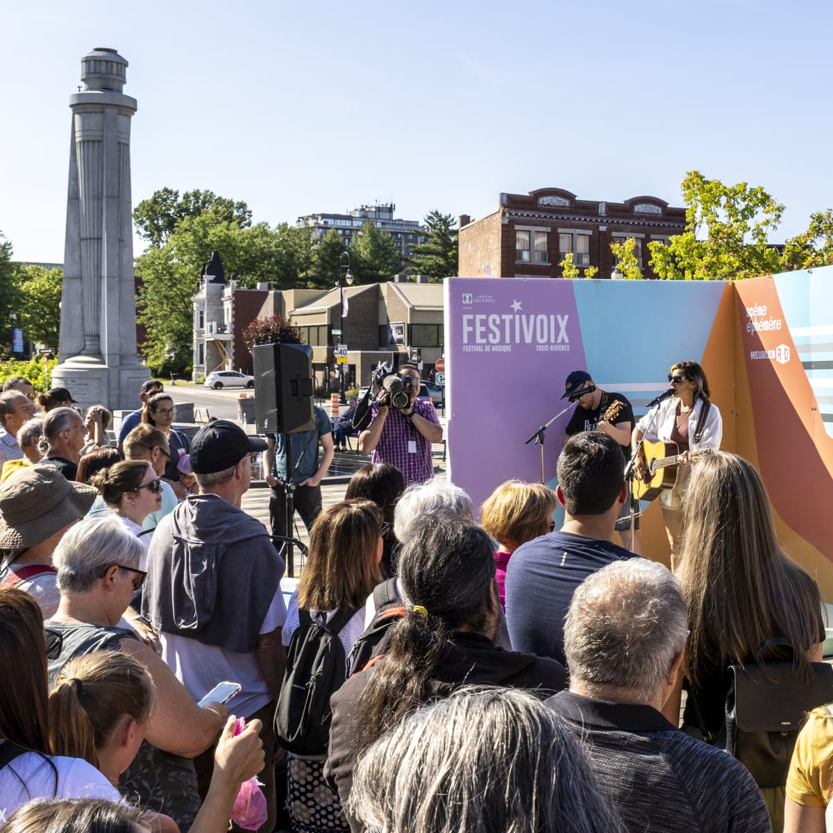 A crowd watches two artists on a small stage at the FestiVoix de Trois-Rivières.