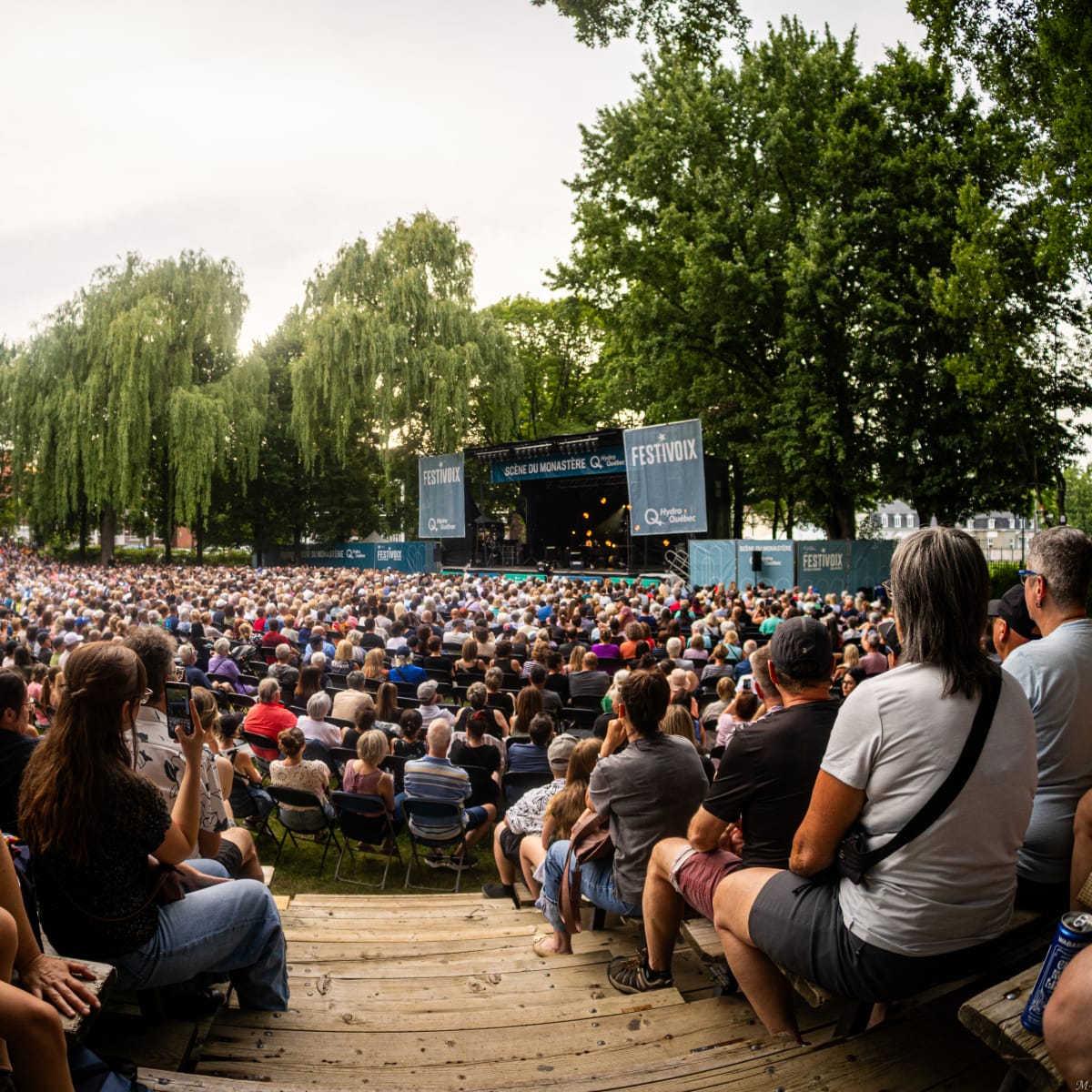 A seated crowd watches an outdoor stage at the FestiVoix de Trois-Rivières.