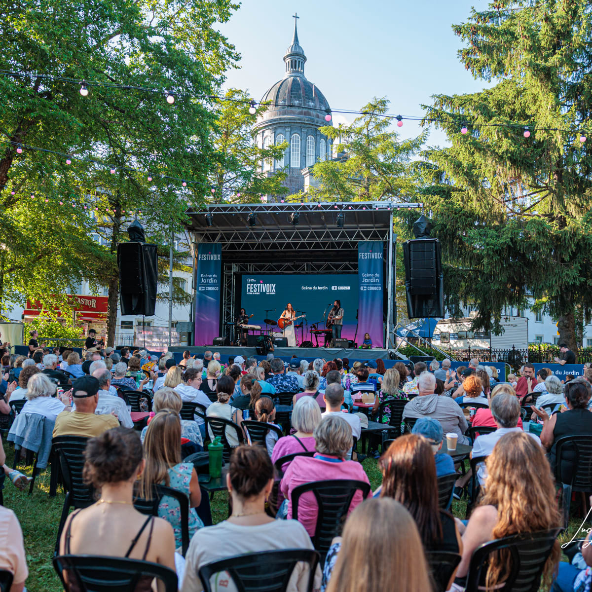 A seated crowd watches a small stage at the FestiVoix festival in Trois-Rivières.