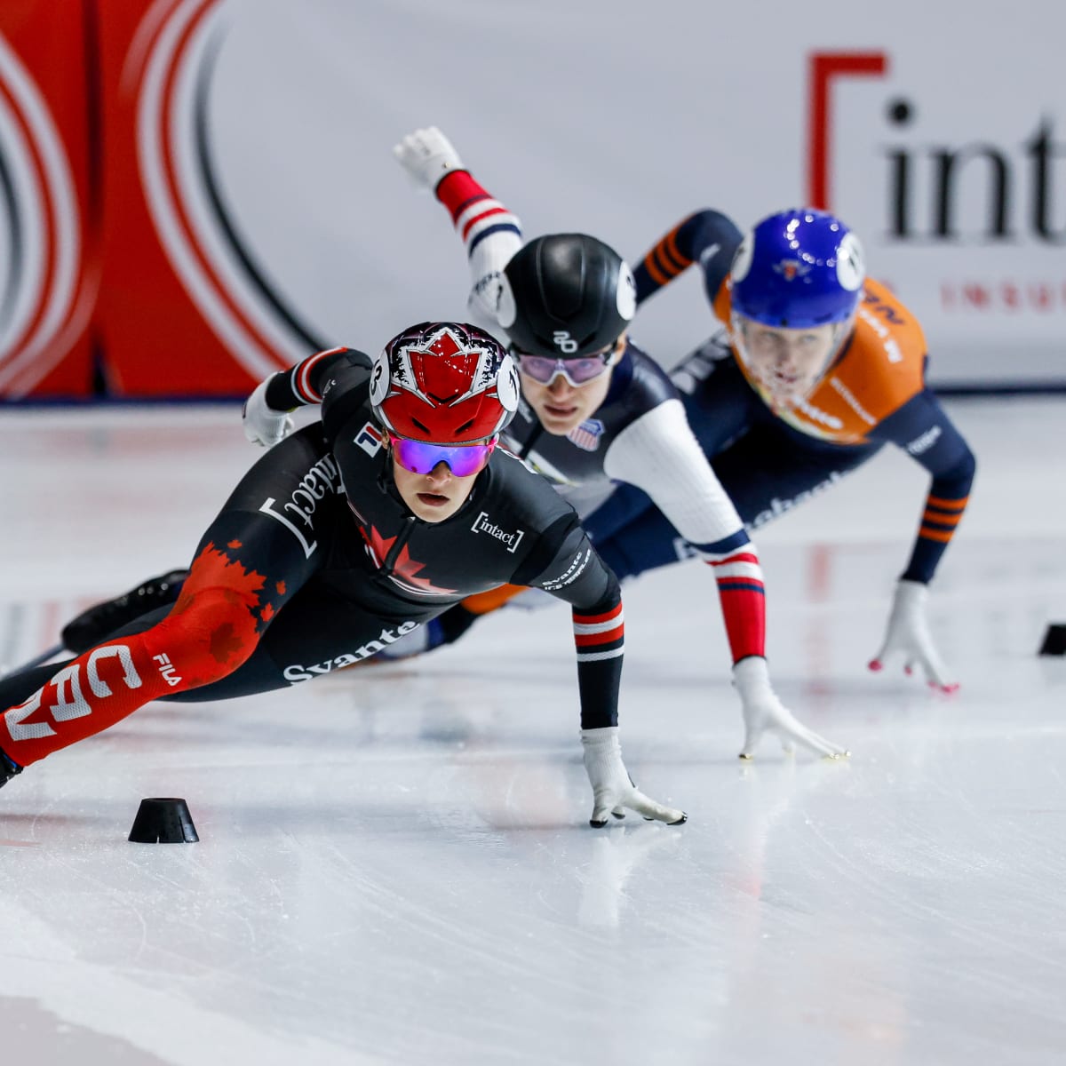Three speed skaters during a turn.