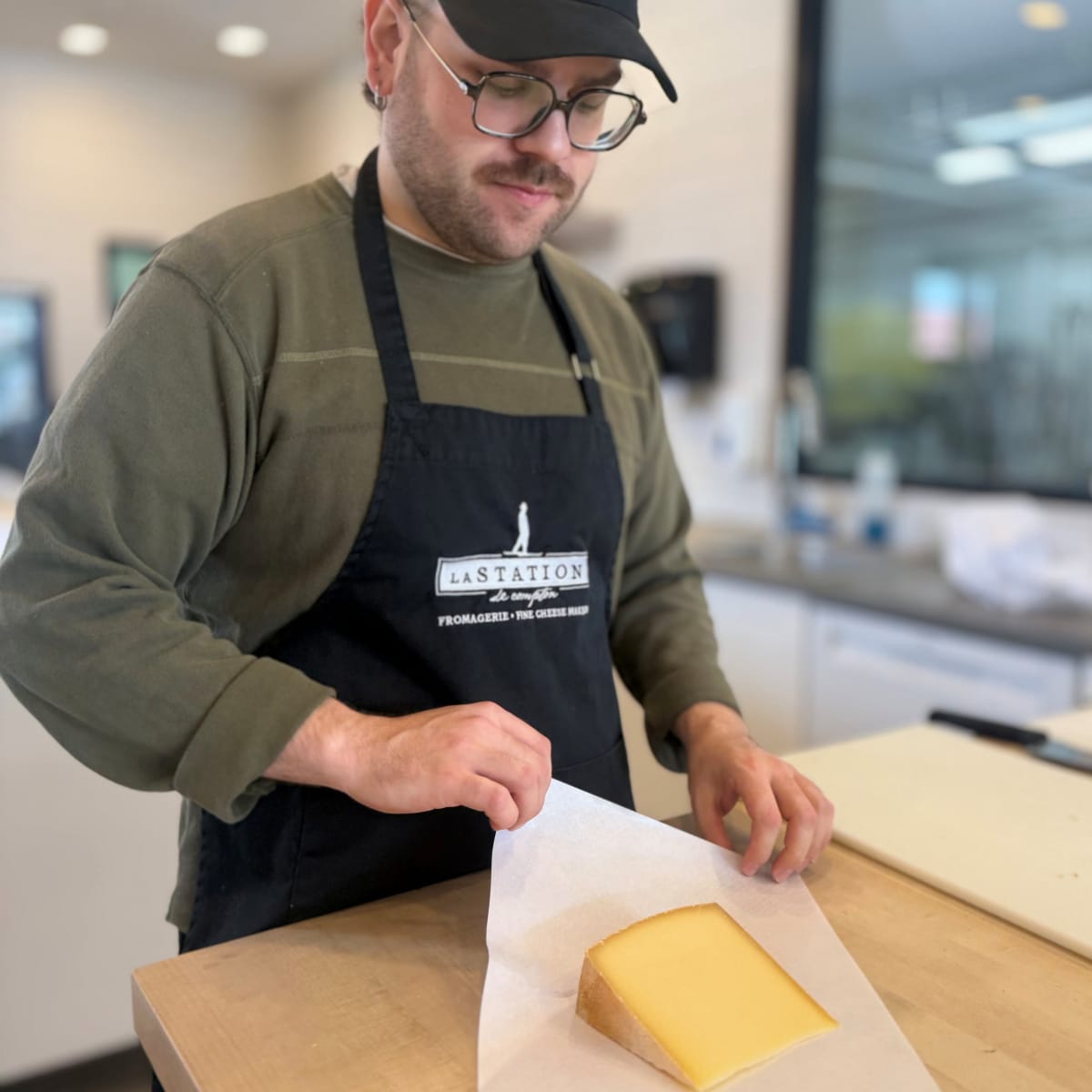Man wrapping a cheese.