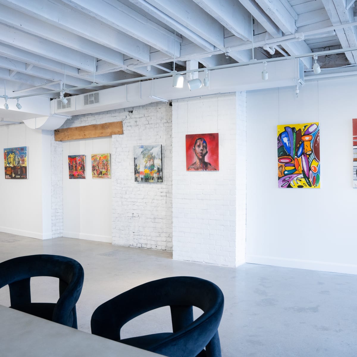 Galerie Angelina - Œuvres d'arts accrochés sur un mur blanc