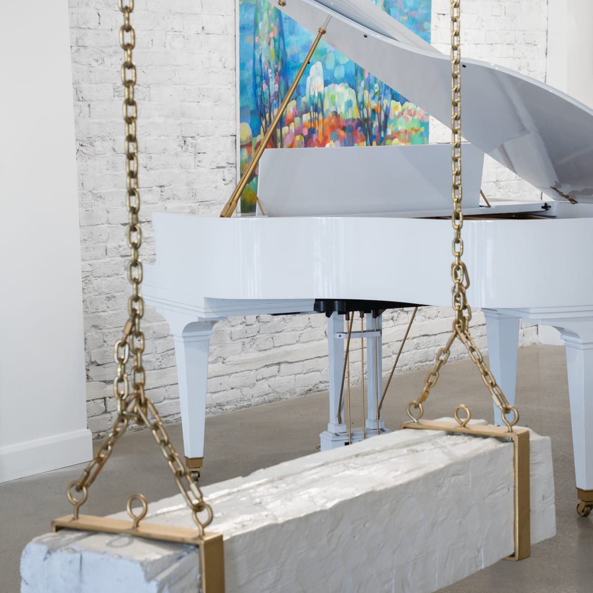 Galerie Angelina - Une balançoire suspendue, un piano blanc et un œuvre d'art accroché au mur