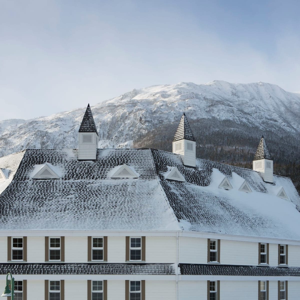 The Gîte du Mont-Albert in winter, with a mountain in the background.