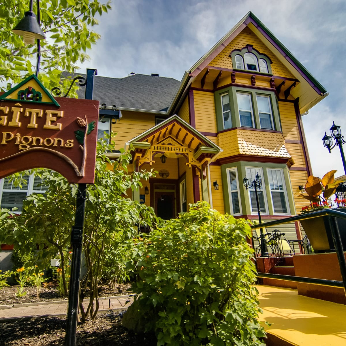 The yellow exterior of Gîte Les Pignons.