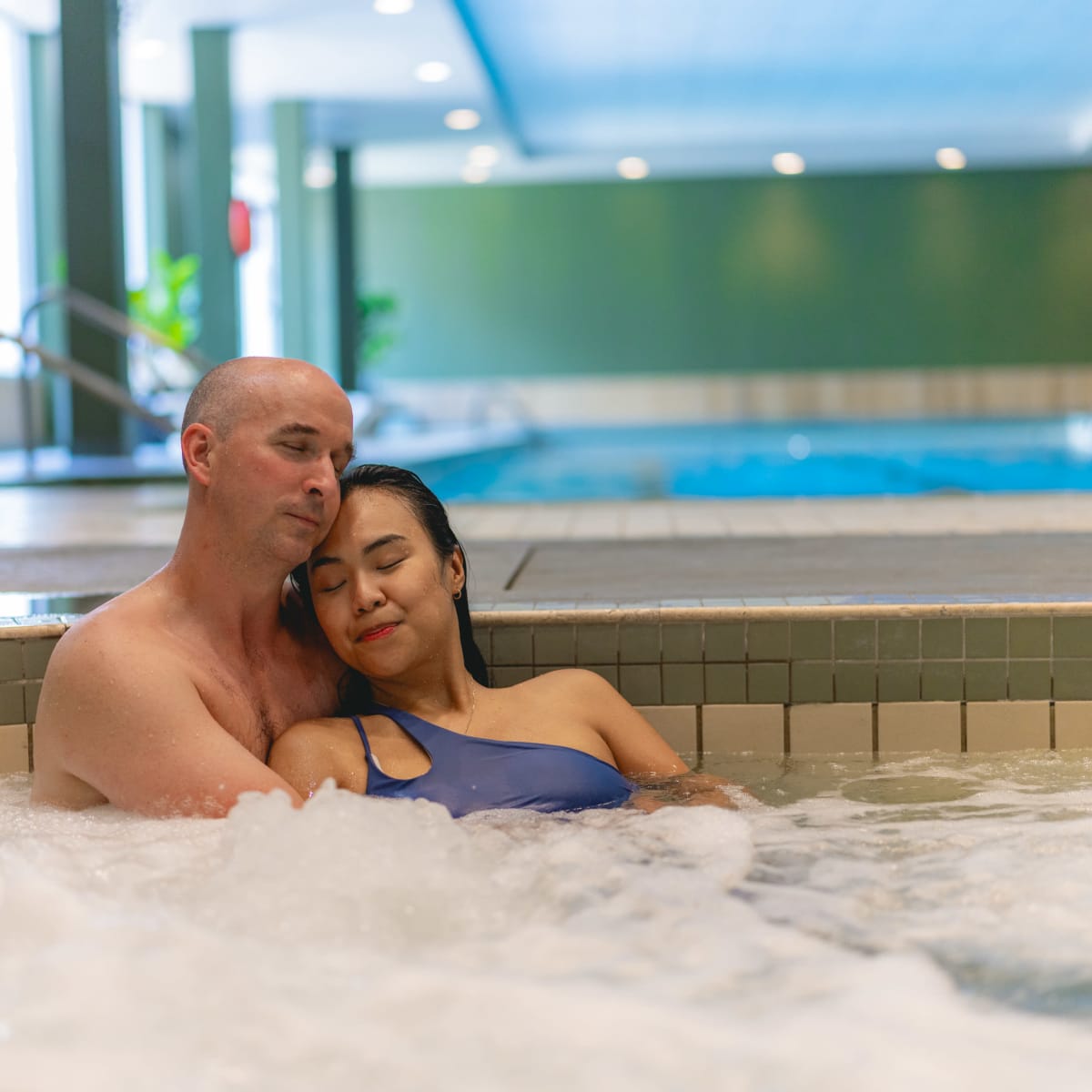 A couple entwined in a hot tub.