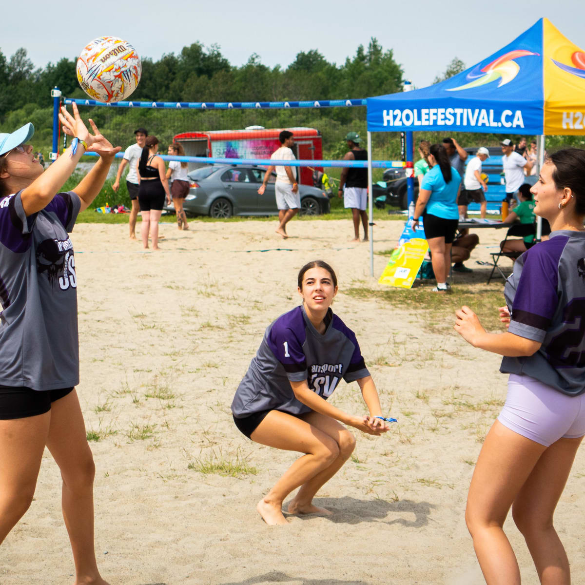 3 young women playing volleyball.