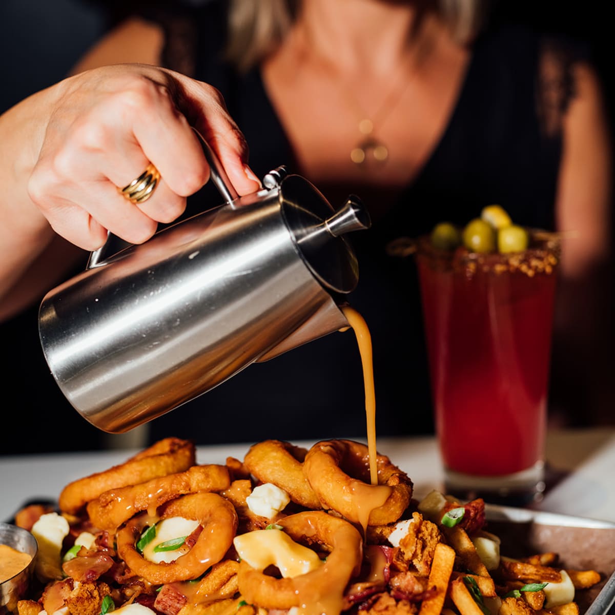 A poutine topped with onion rings.
