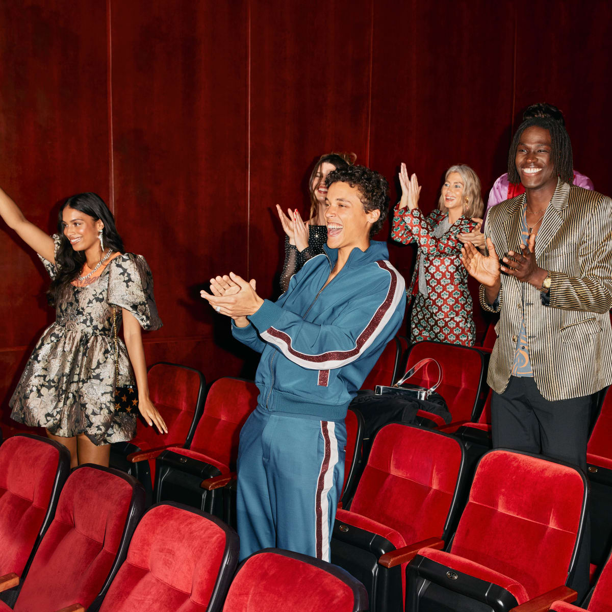 A group of people applauding in a theater.