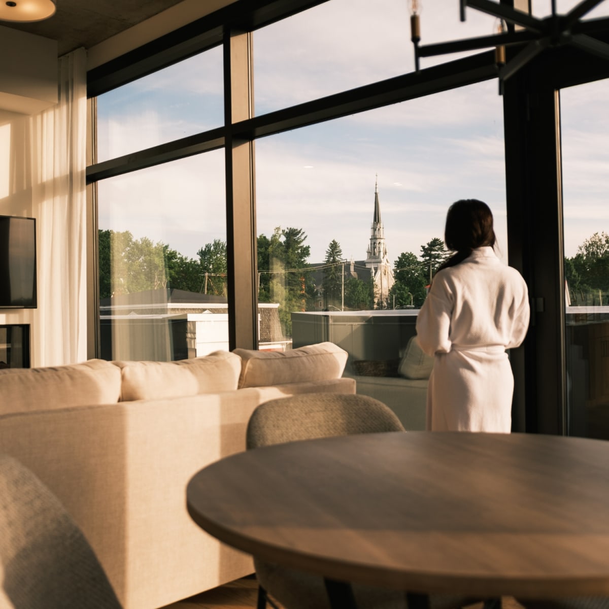 Woman wearing a bathrobe inside a condo-style lodging.