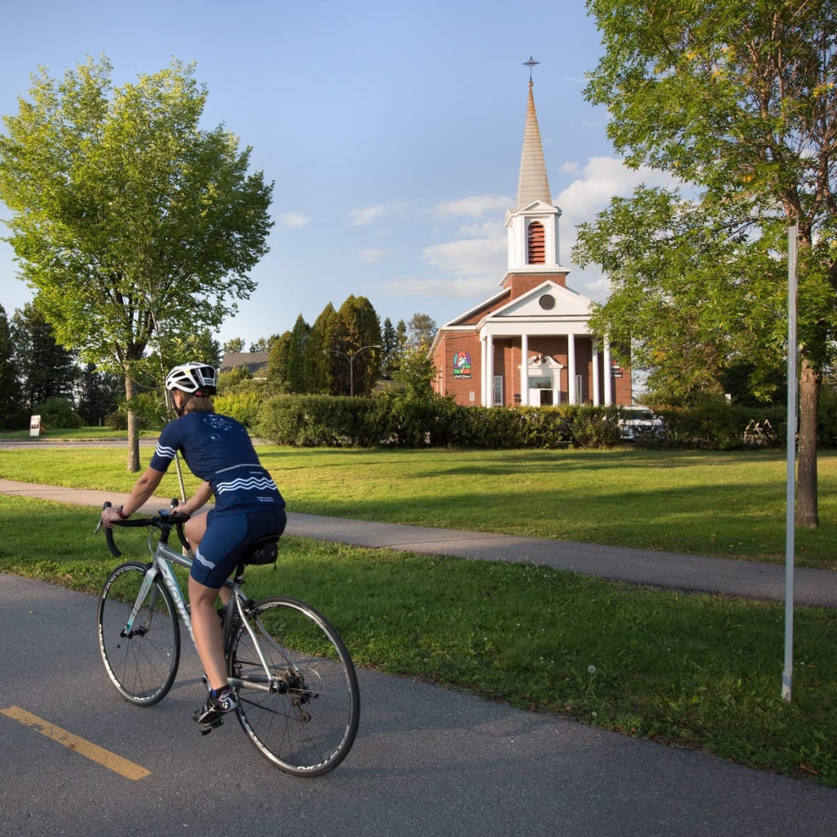 Personne en vélo devant l'hôtel Le Sainte-Crème.