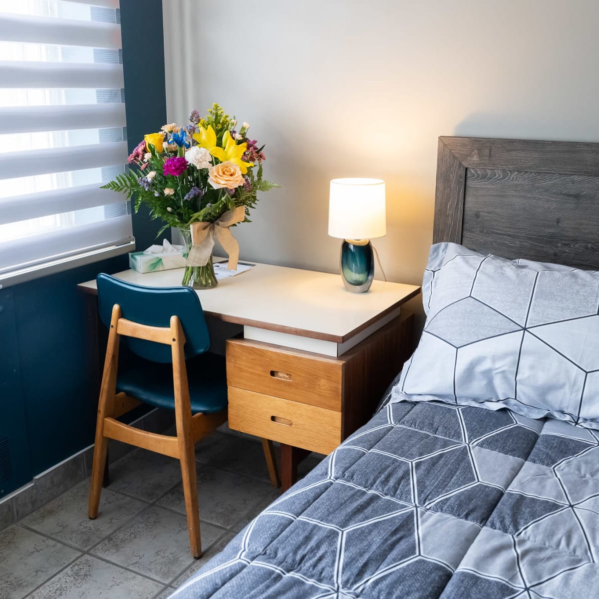 Chambre de l'Hôtel Manoir d'Youville avec lit et petit bureau.