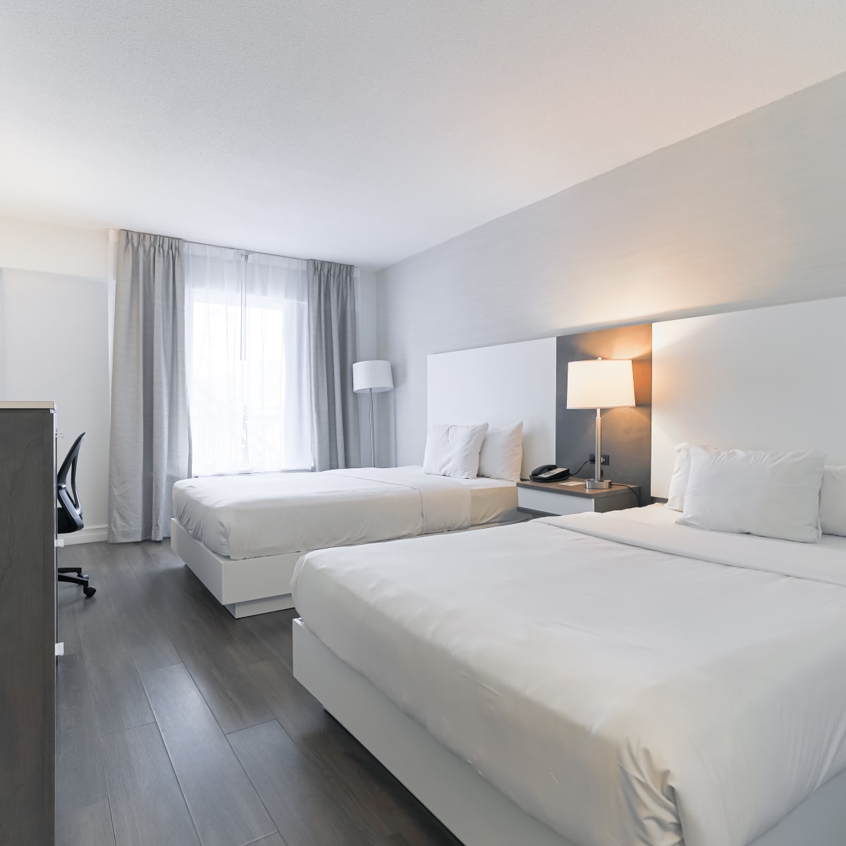 A room with two double beds at Hôtel Universel Québec.