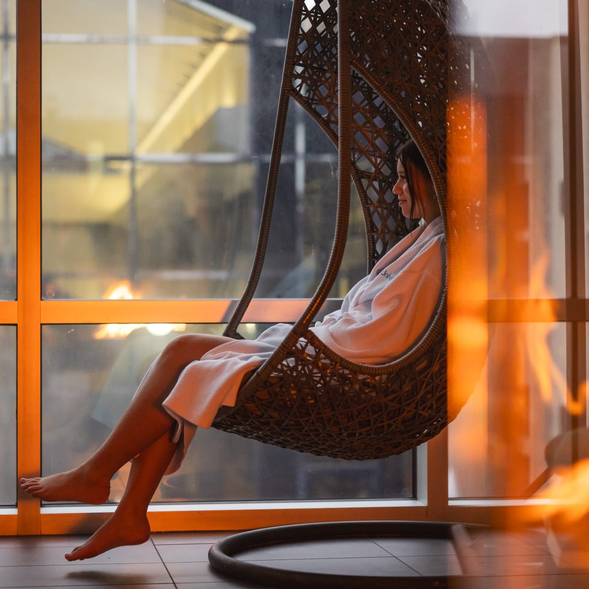 Hôtel Universel Rivière-du-Loup - A person in a bathrobe is seated in a hanging chair