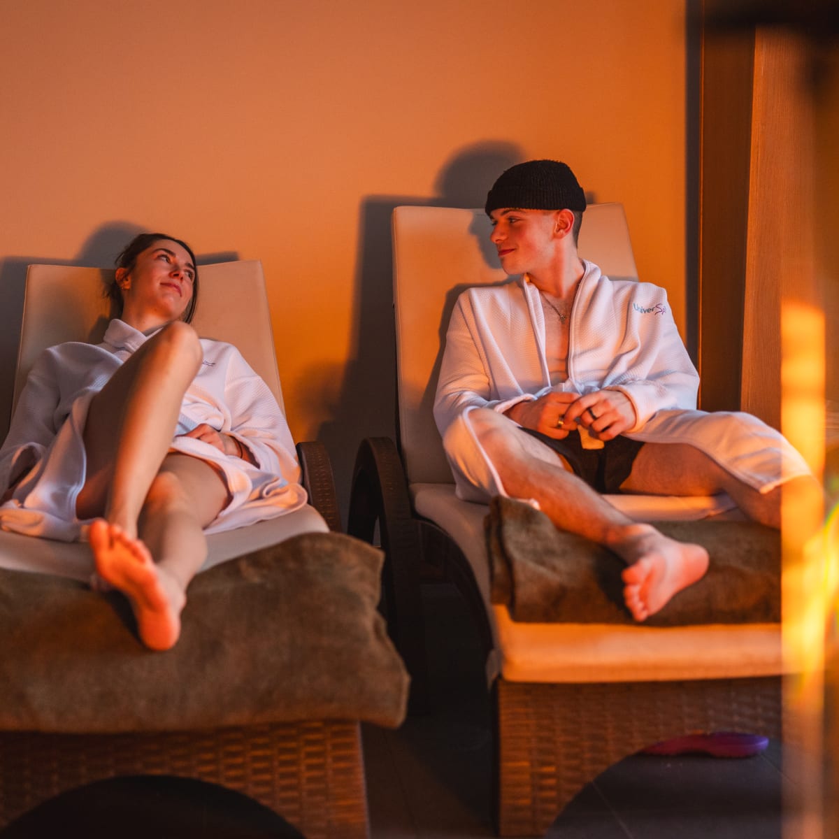 Hôtel Universel Rivière-du-Loup - Two people in bathrobes are lying in front of a fire