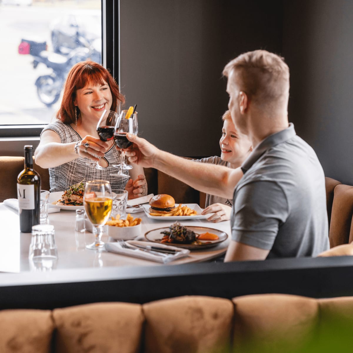 Famille portant un toast au restaurant.