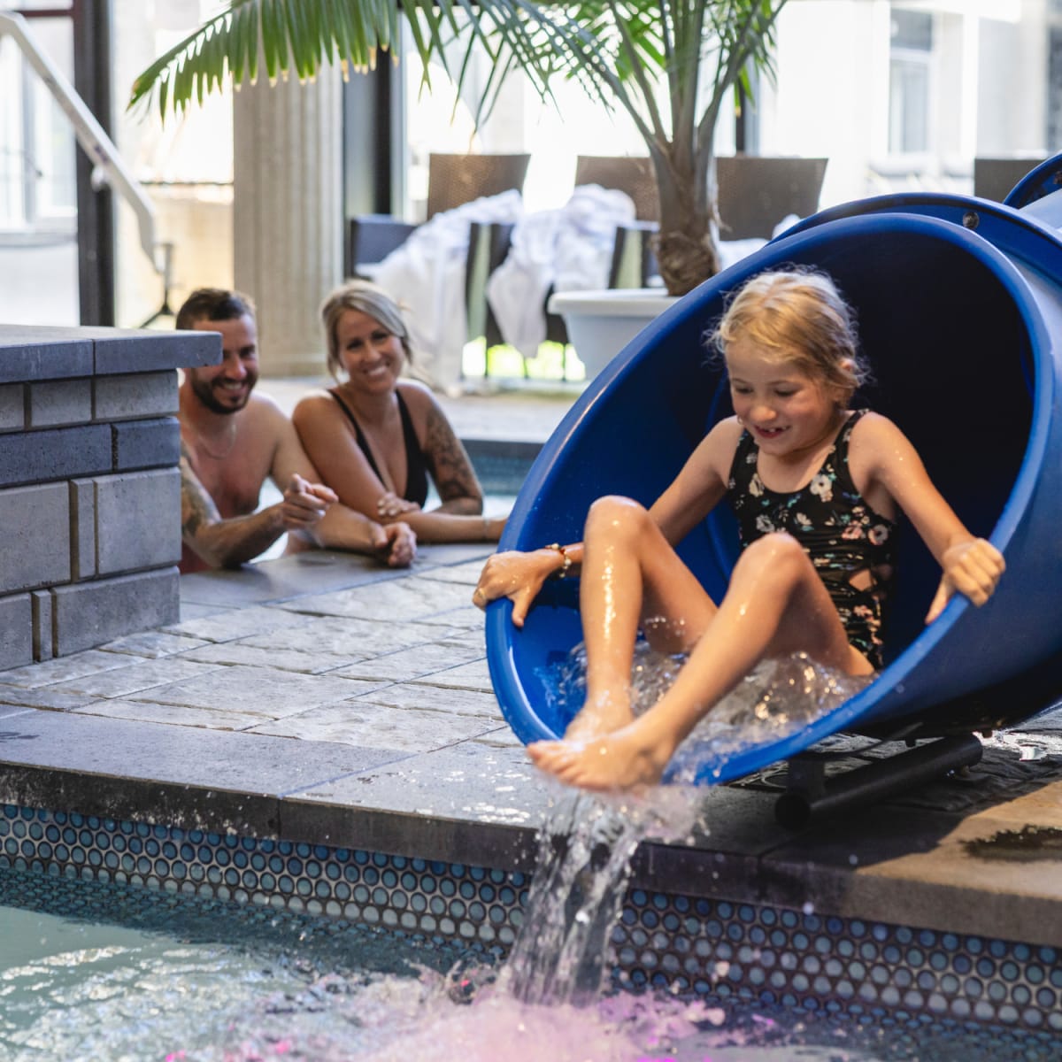 Fillette dans une glissade d'eau à la piscine.