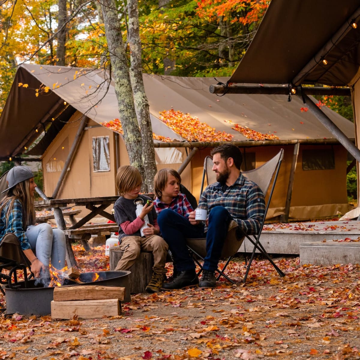 Famille devant une tente Huttopia à l'automne.