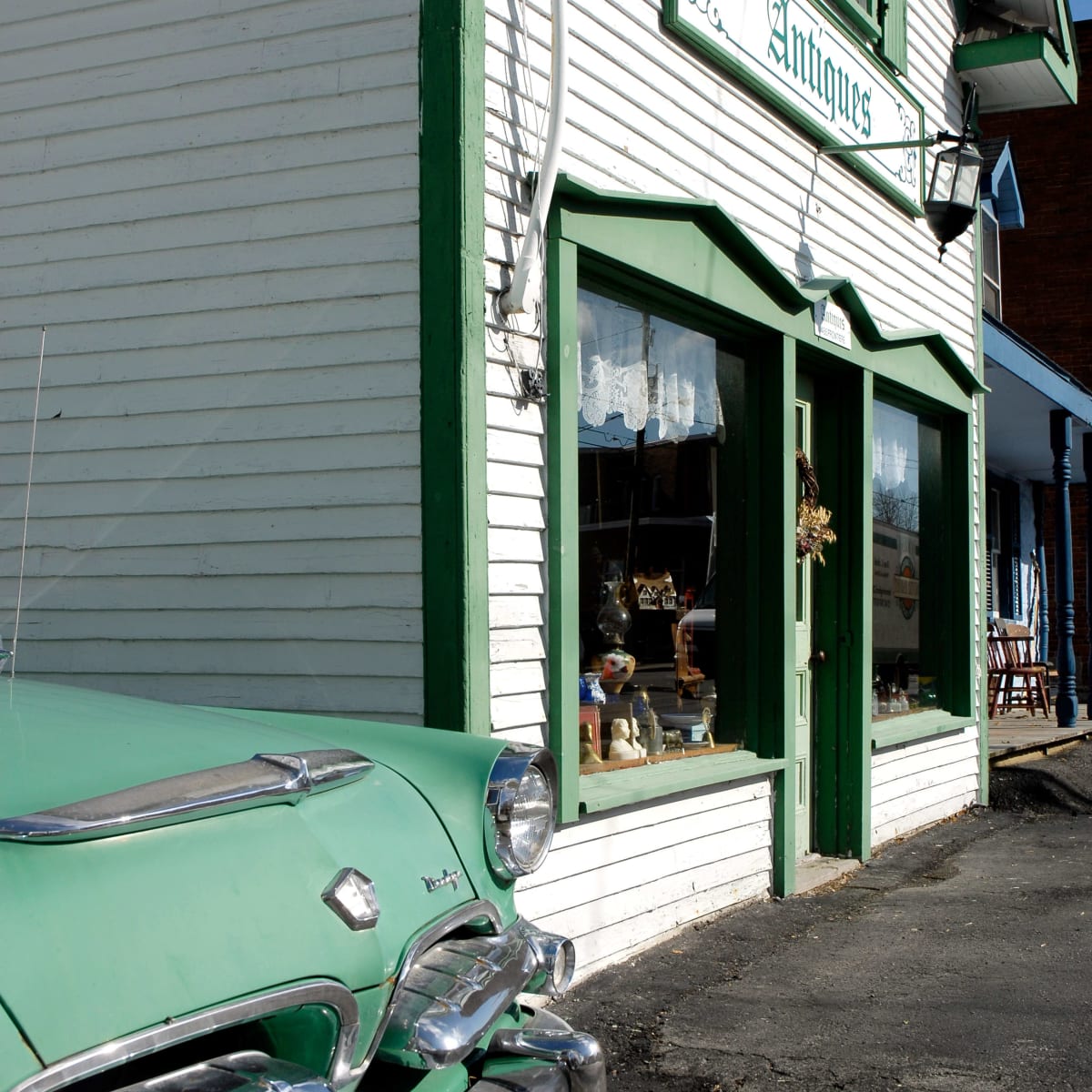 Voiture antique à côté d'une boutique d'antiquité.