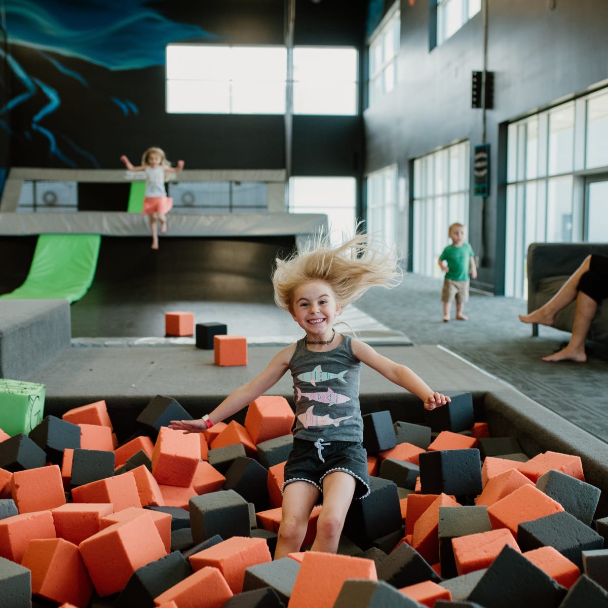 A girl jumping into a foam block pit at iSaute.