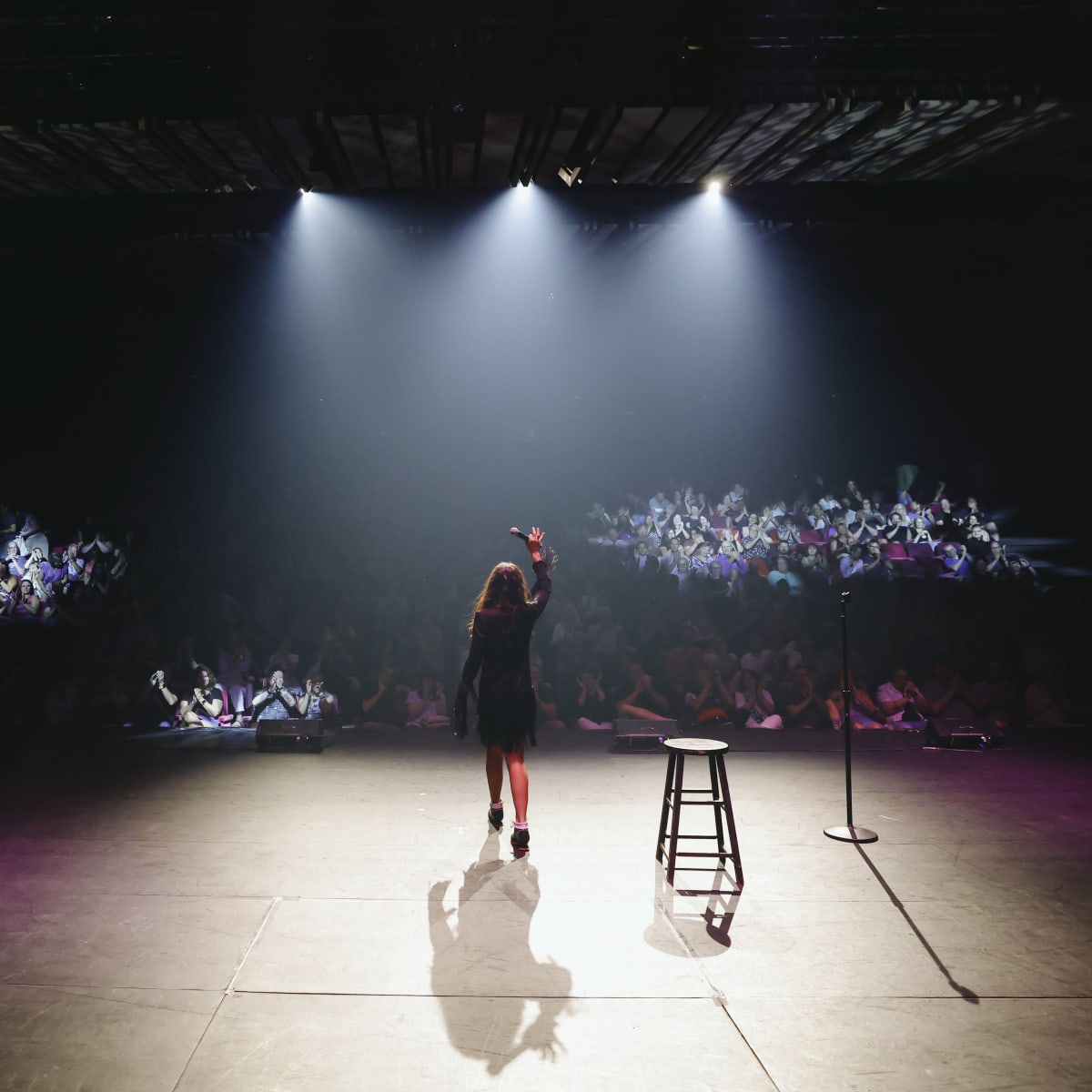 Just For Laughs MONTRÉAL - On a stage, a comedian is illuminated by spotlights.
