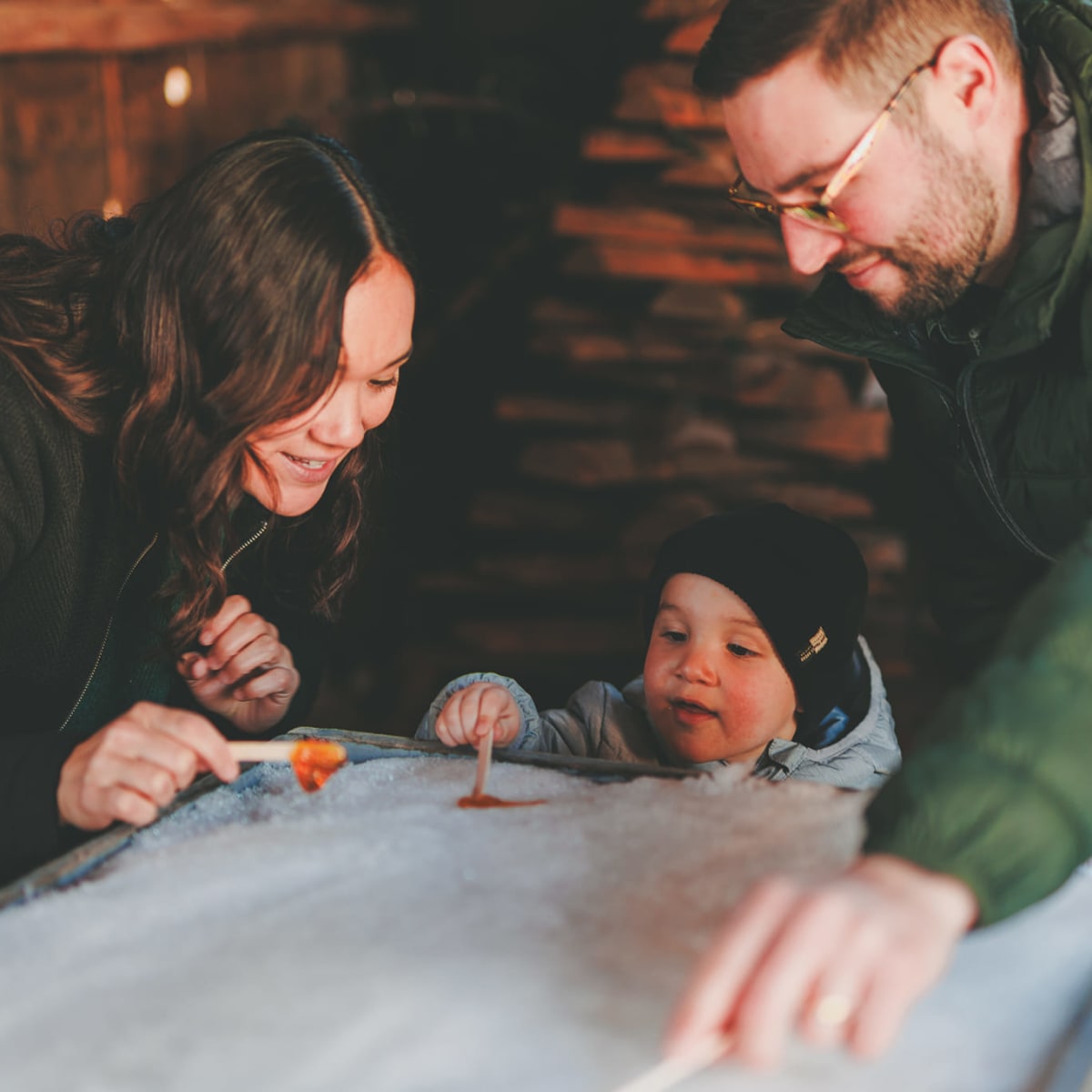 A family and maple taffy on snow at Cabane Osias.