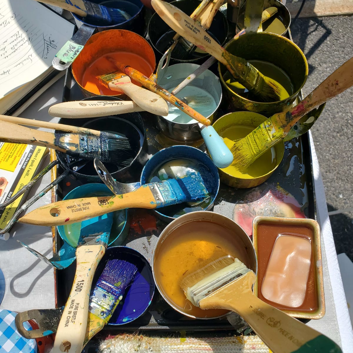 Several open paint containers with brushes.