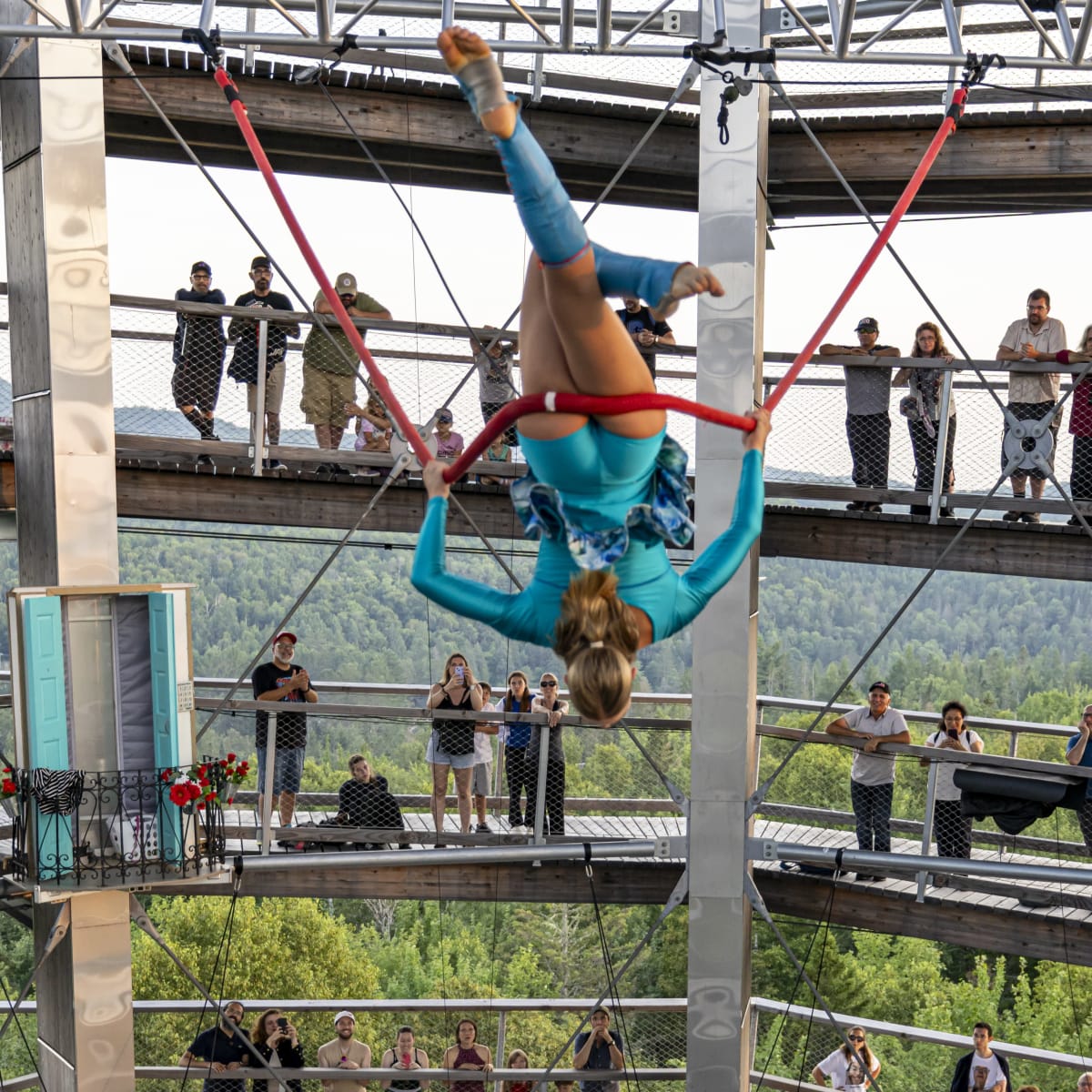 An acrobat hanging upside down.