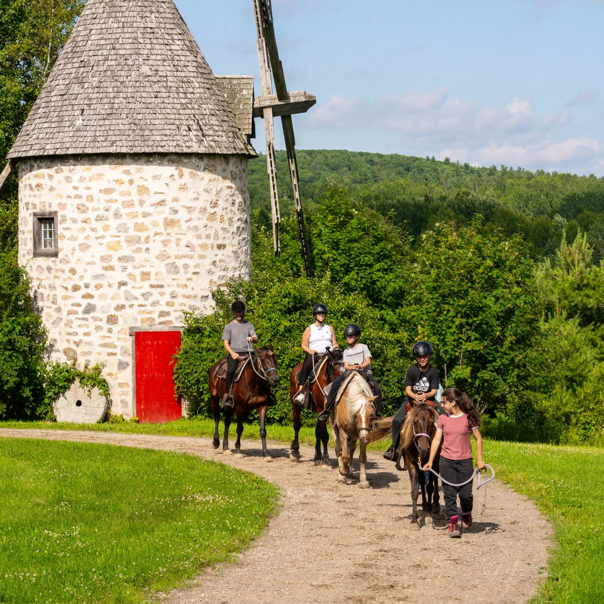 Group horseback riding near the mill.