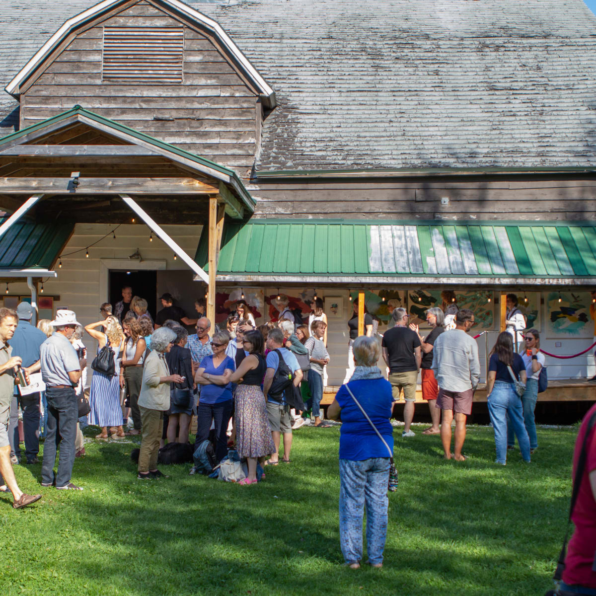 Les Correspondances d’Eastman - A crowd of people gathered in front of an old wooden barn