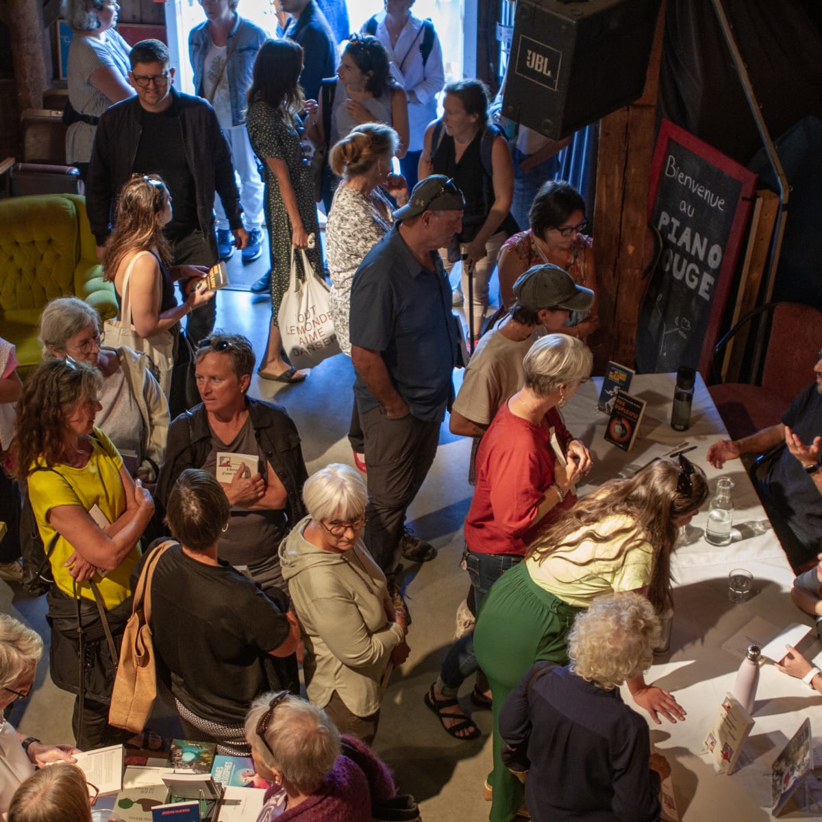 Les Correspondances d’Eastman - A crowd of people gathered in an interior space