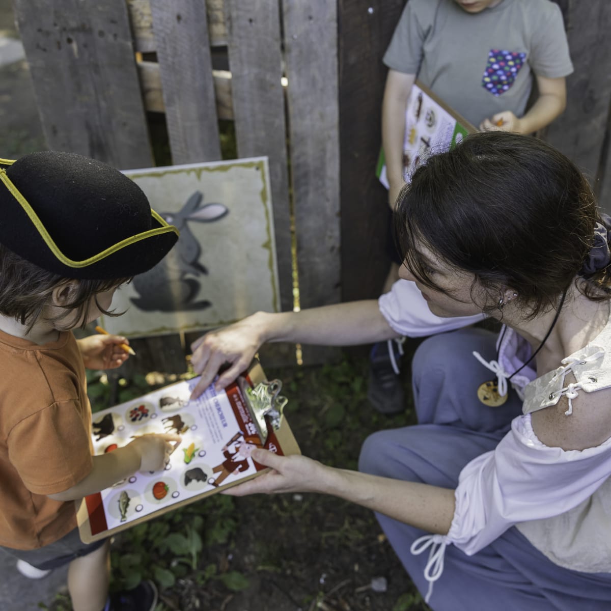 Les Fêtes de la Nouvelle-France - A woman helps two children