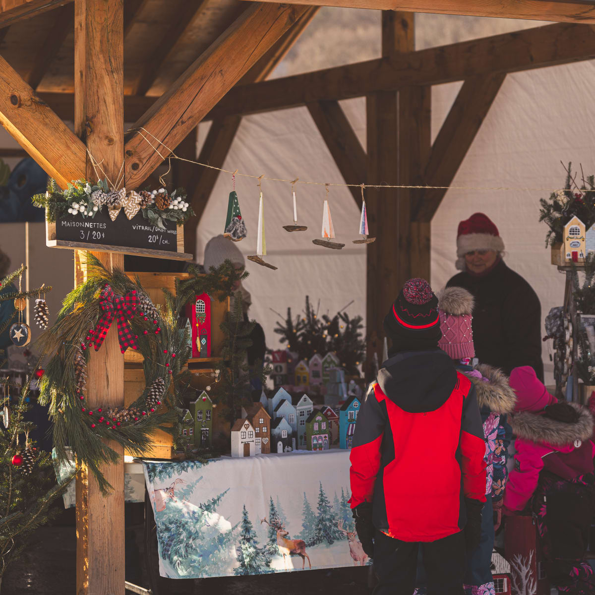 Des personnes à un kiosque d'un Marché de Noël en Memphrémagog.