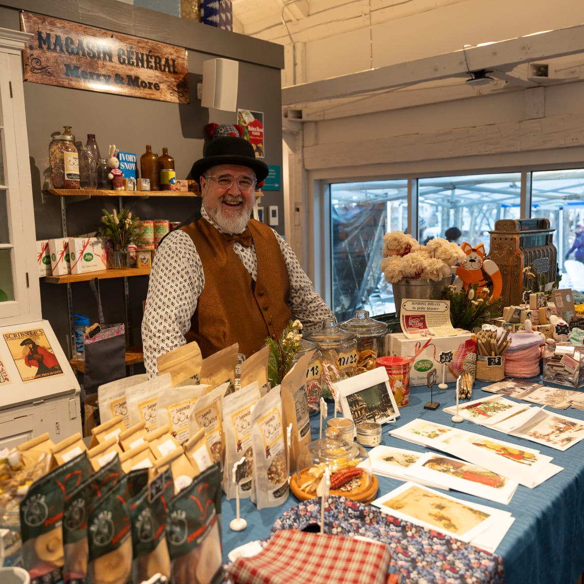 Un vendeur derrière son kiosque à l'intérieur à un Des personnes à un kiosque d'un Marché de Noël en Memphrémagog.