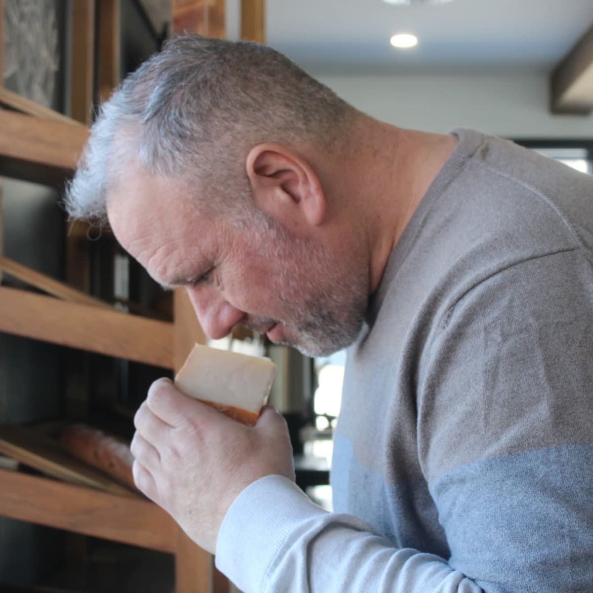 A man looking at a fine cheese.