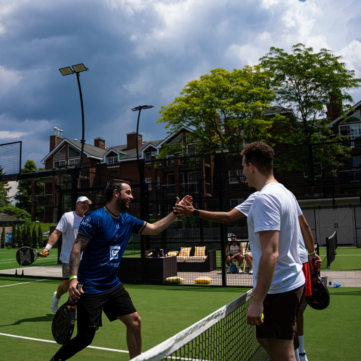 Deux hommes en train de se serrer la main sur un terrain de padel au Manoir-Saint-Sauveur.