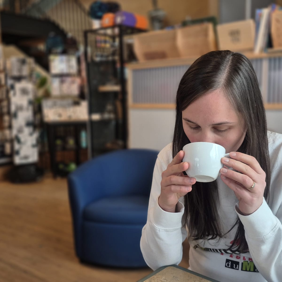 Woman drinking a coffee in a shop.