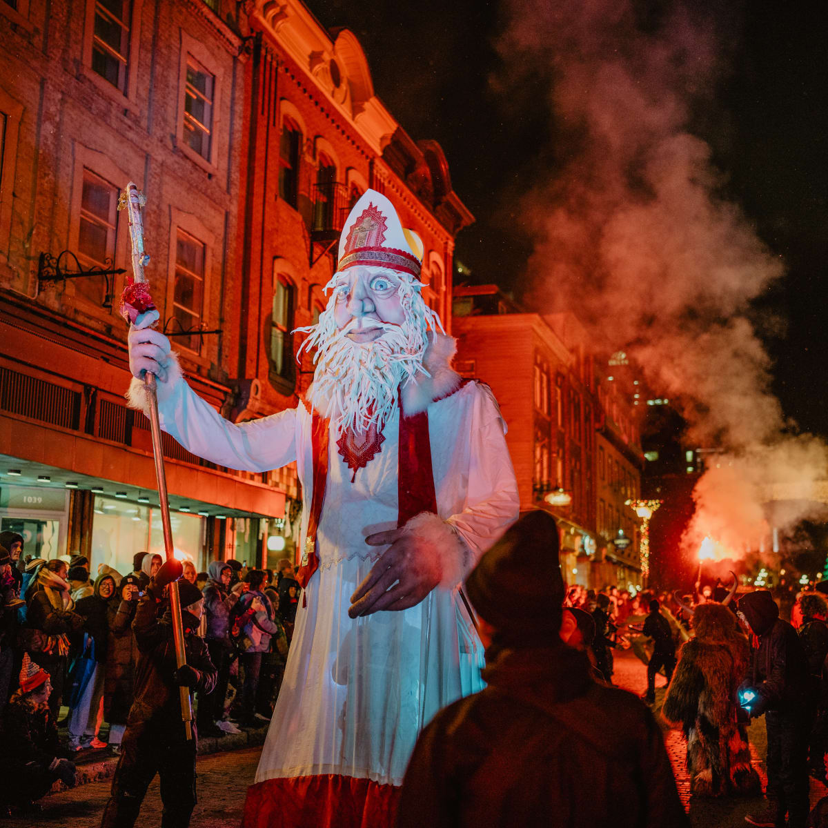 Quebec City German Christmas Market - large Santa Claus puppet, standing in the middle of a busy and illuminated street at night